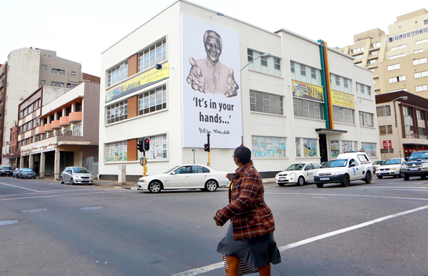 RAJESH JANTILAL [AFP] - Une immense banderole de l'ancien président Nelson Mandela plane au-dessus de l'Hindu Tamil Instituite à Durban le Juillet 17,2013 en préparation pour célébrer le 95ème anniversaire de Nelson Mandela et à commémorer la Journée internationale Nelson Mandela, le 18 Juillet