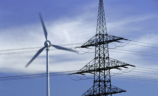 Une éolienne : symbole de l’énergie propre transportée par les pylônes.